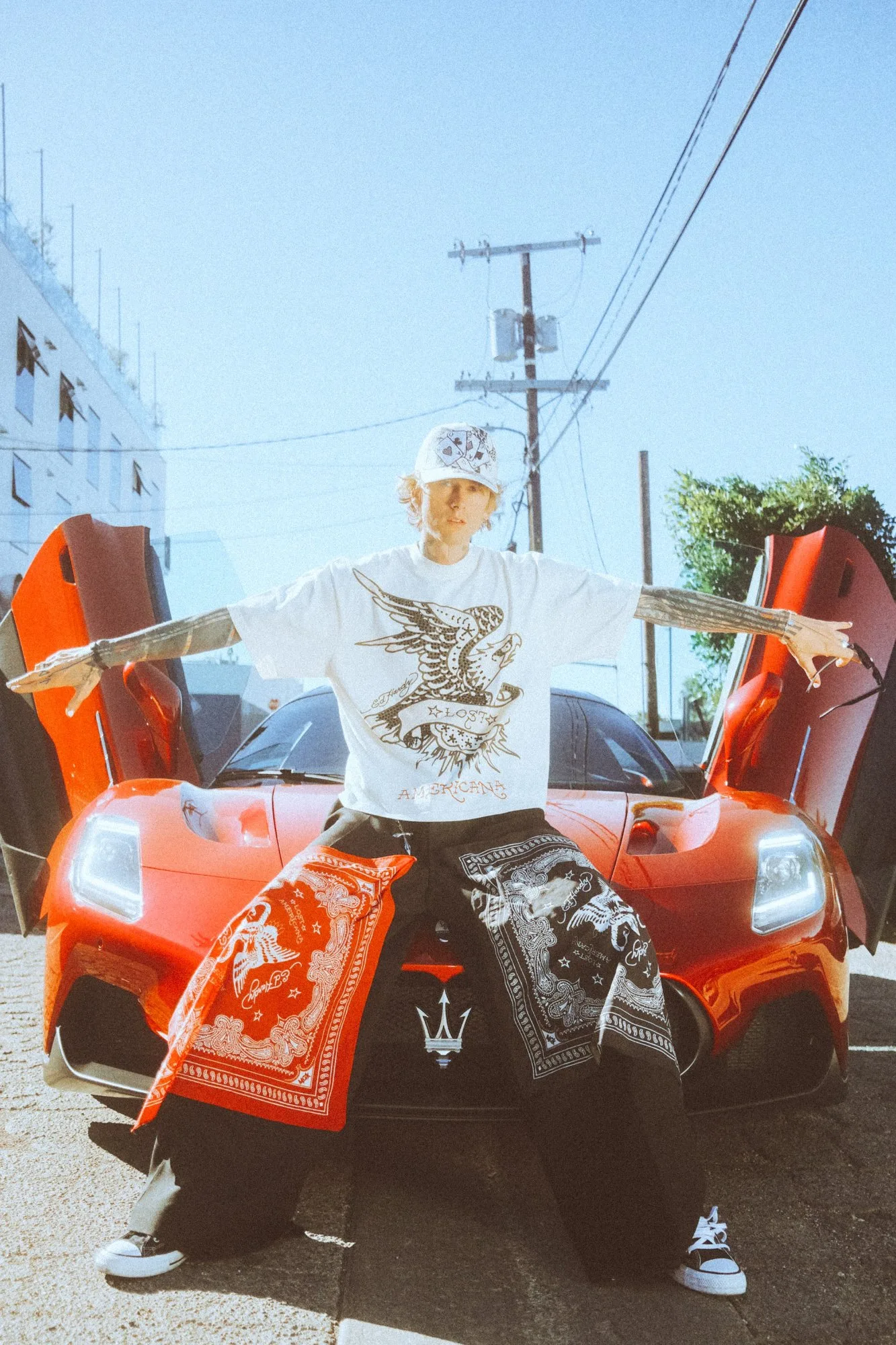 mgk in the white Ed Hardy x mgk set between Lamborghini doors. Photo by Sam Cahill