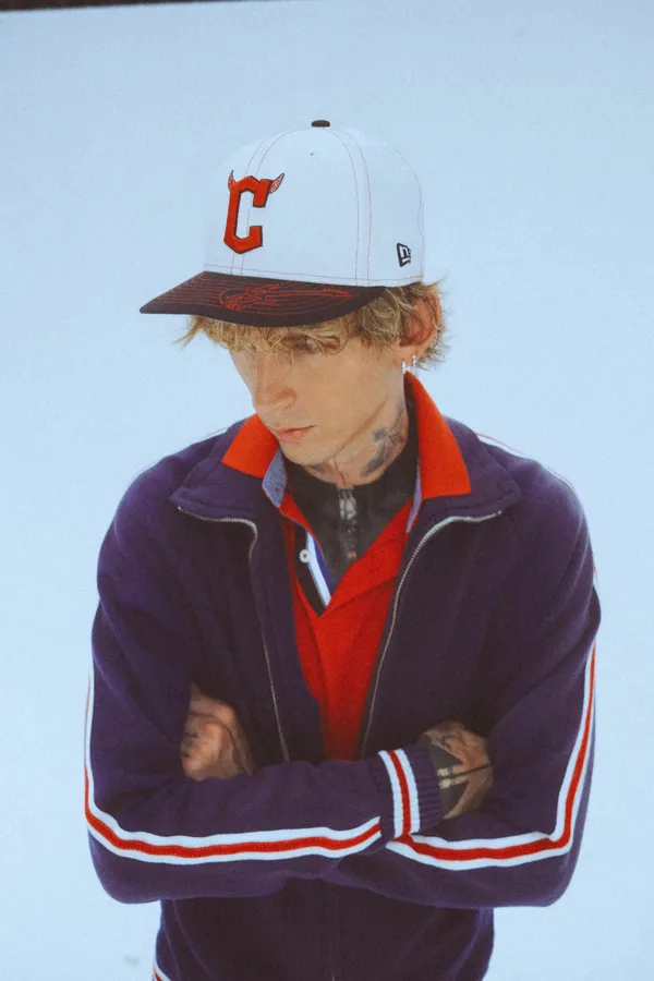 mgk in the Guardians track jacket and C cap. Photo by Sam Cahill