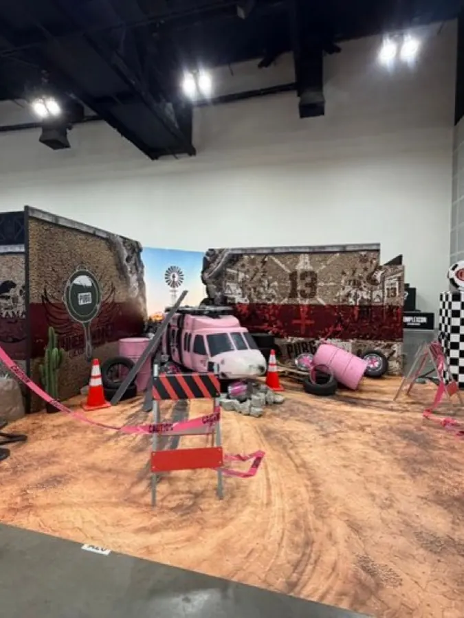 Wide view of the PUBG x Floor 13 booth with dirt floor and barricades