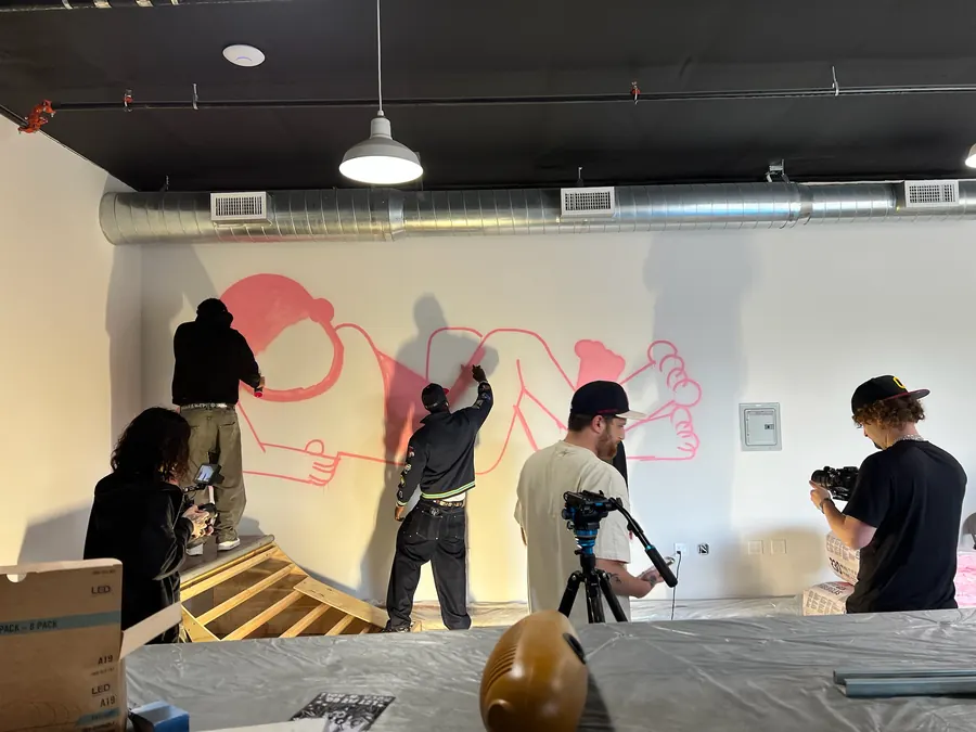 Slawn painting a mural while the Study Hall crew films